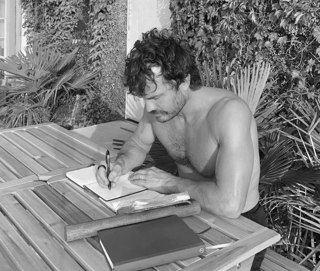 Carter Twitty writing in a notebook at an outdoor table